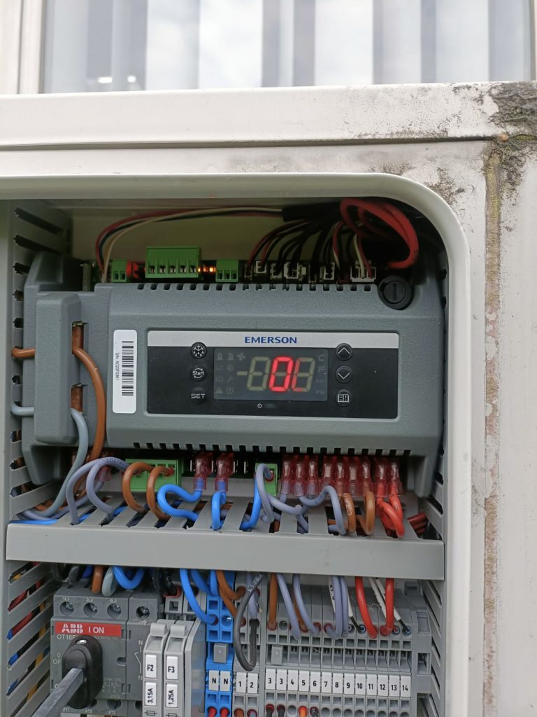 Thermostat numérique Emerson installé dans un boîtier électrique de système frigorifique professionnel lors d’une intervention en Belgique